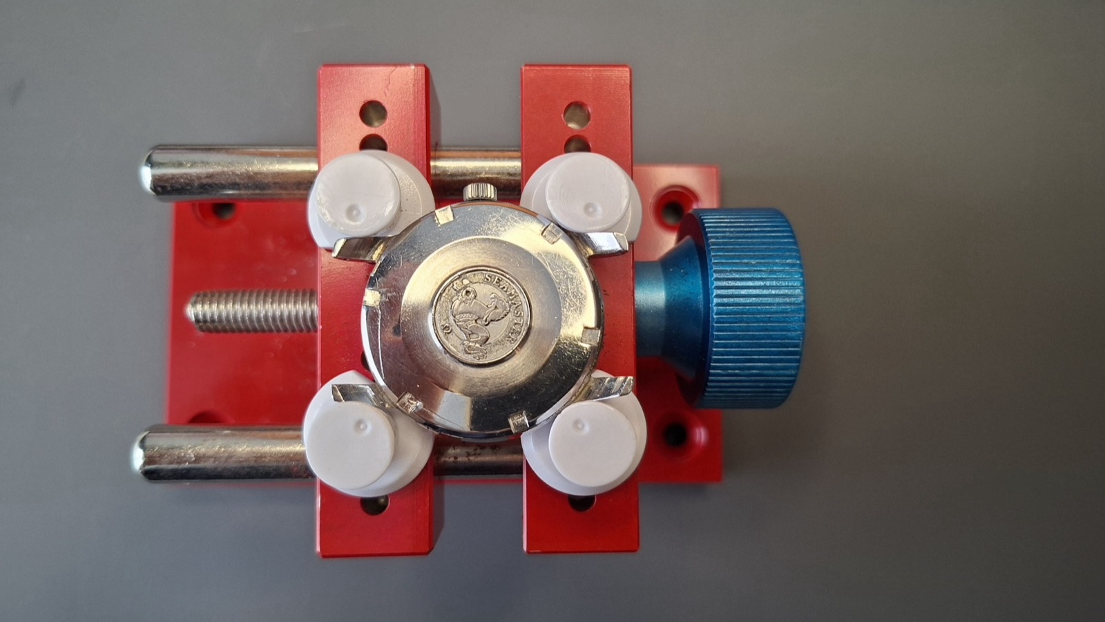 Omega watch clamped in a case holder vise